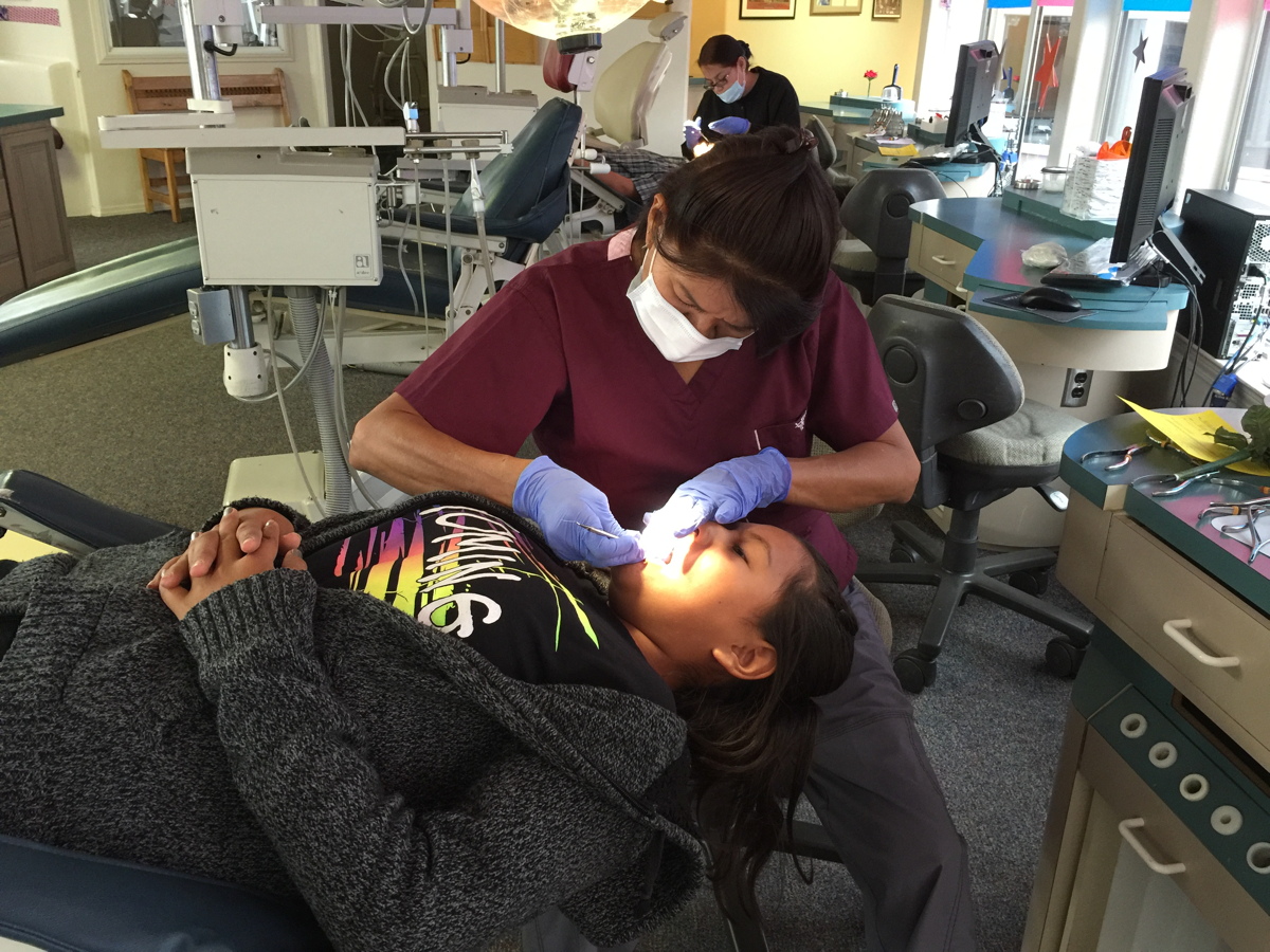 dental assistant treating patient in clinic